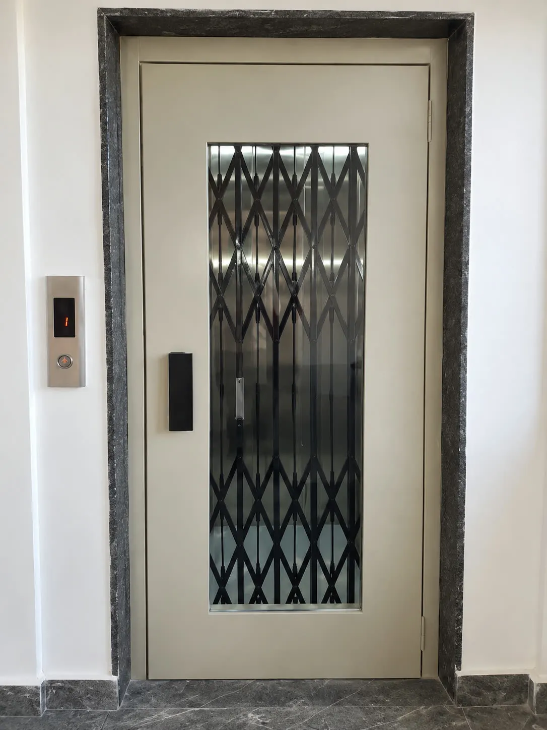 Home lift landing with a manual door in a granite surround