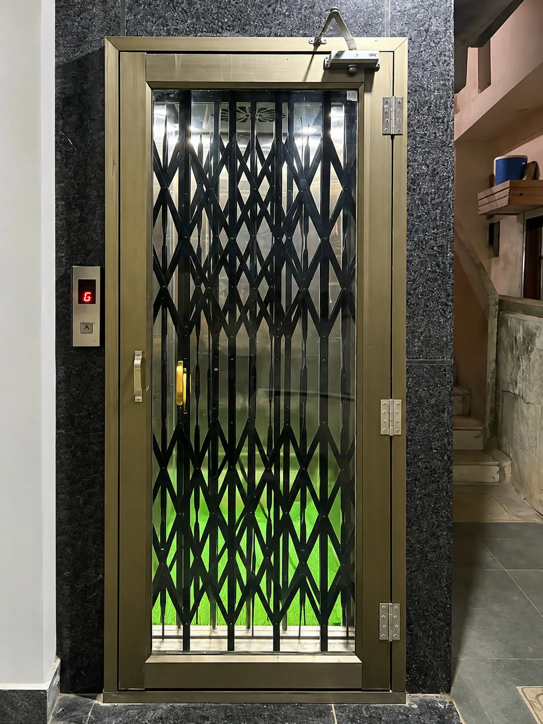 Home lift with a bronze-finish collapsible gate